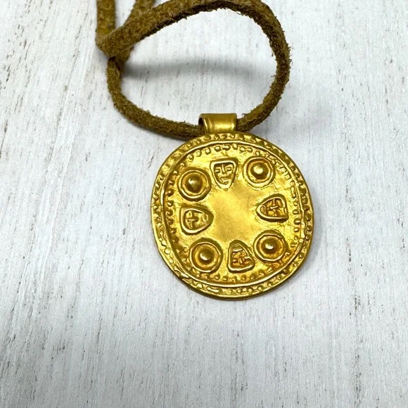 Mayan design gold tone pendant purchased in Costa Rica, on golden suede cord